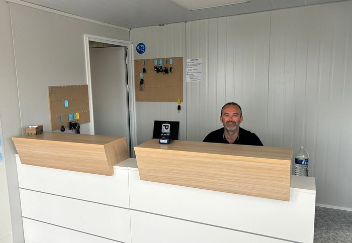 Un uomo seduto alla scrivania di un piccolo ufficio.